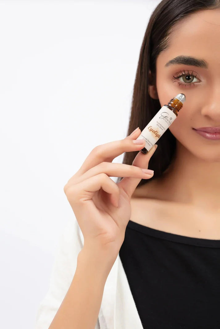 Woman holding a skincare product close to her face on a white background