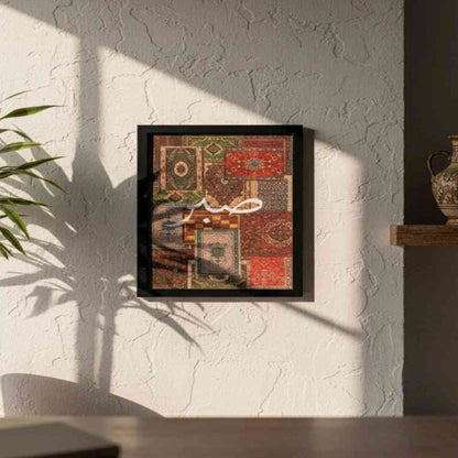 sabr Framed artwork on a wall with a plant and vase in the background